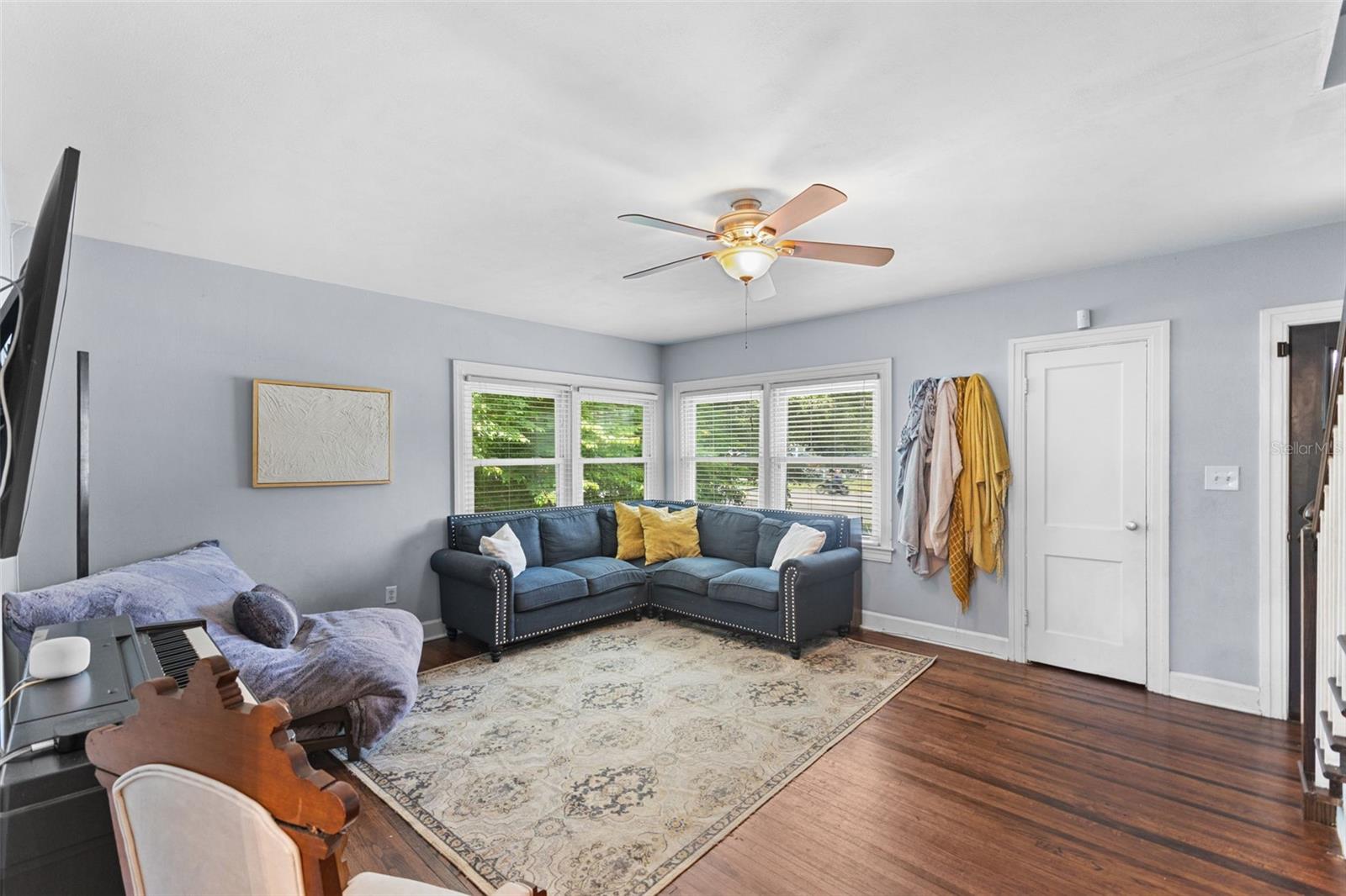 Spacious, open-concept living and dining area anchored by warm hardwood floors and classic architectural arches.