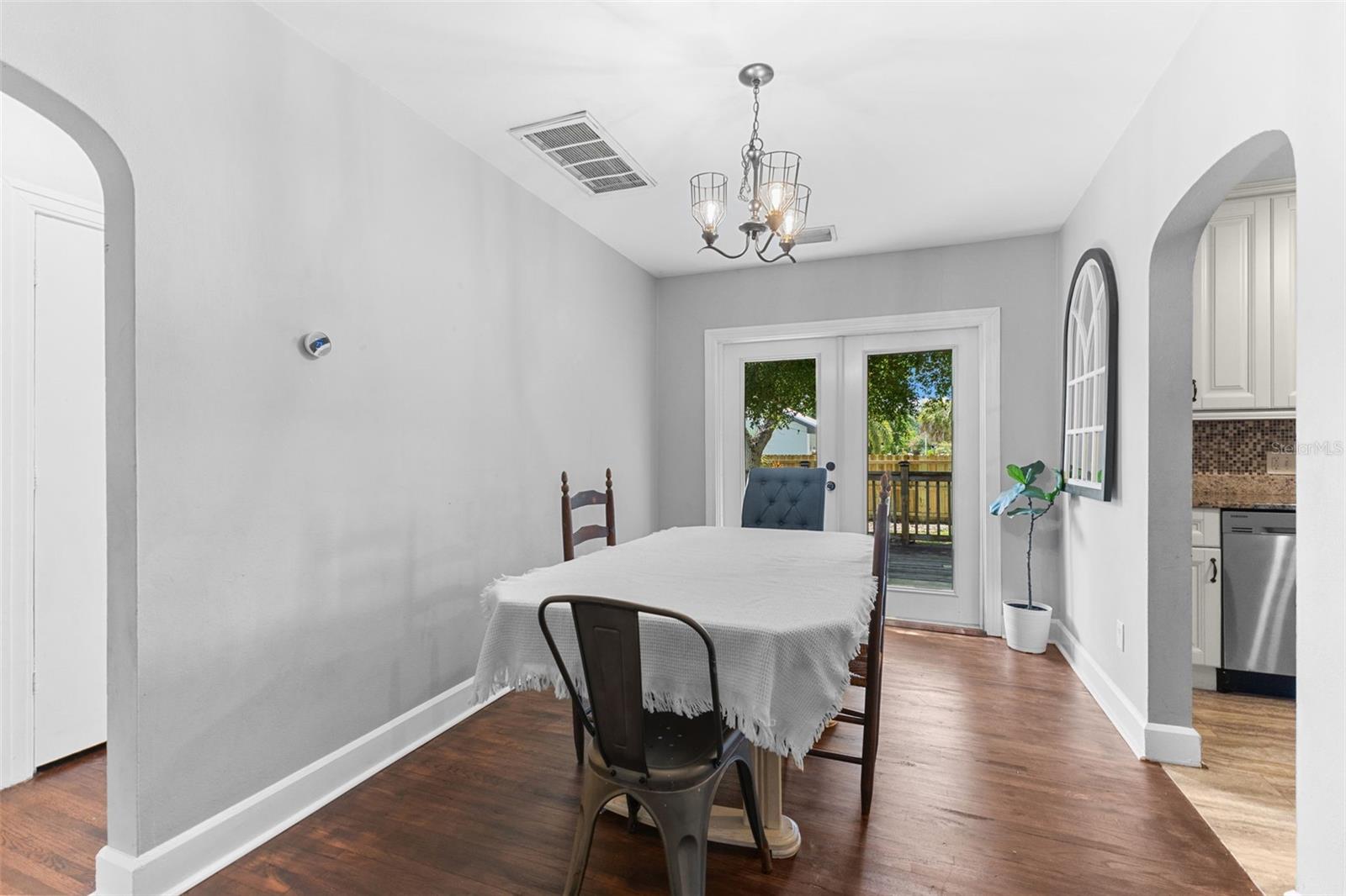 Signature arched doorways and open sightlines connect the dining room to the kitchen and living areas.