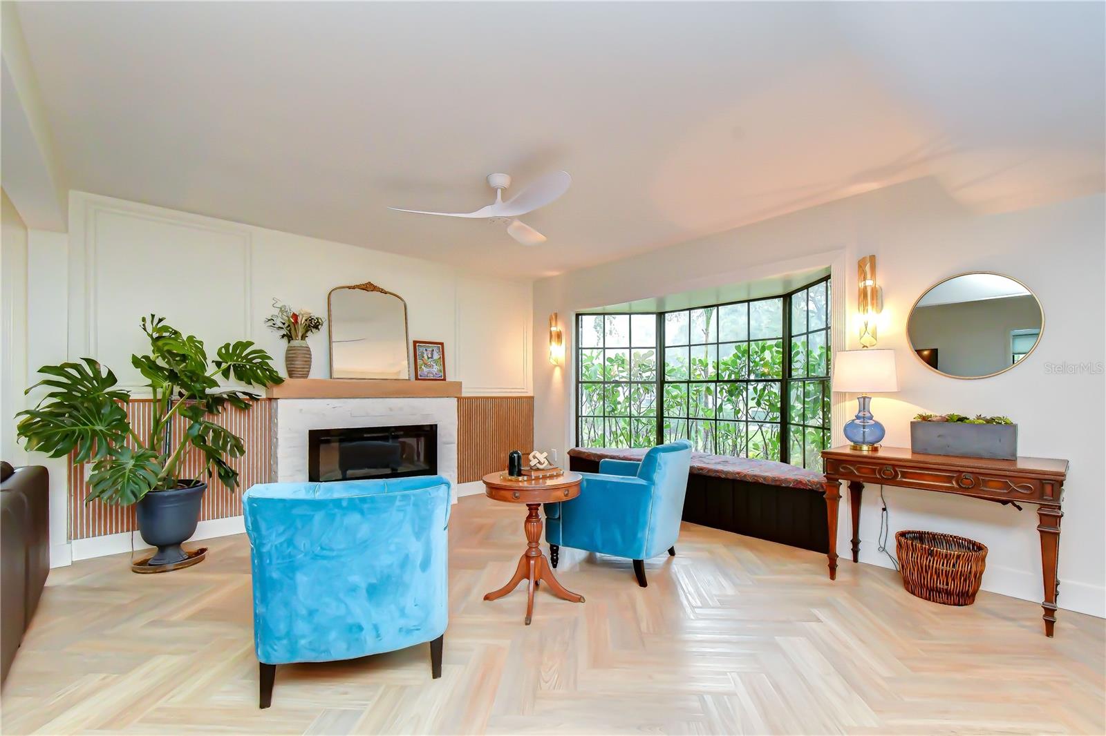 Elegant gathering space with fireplace and bay window.