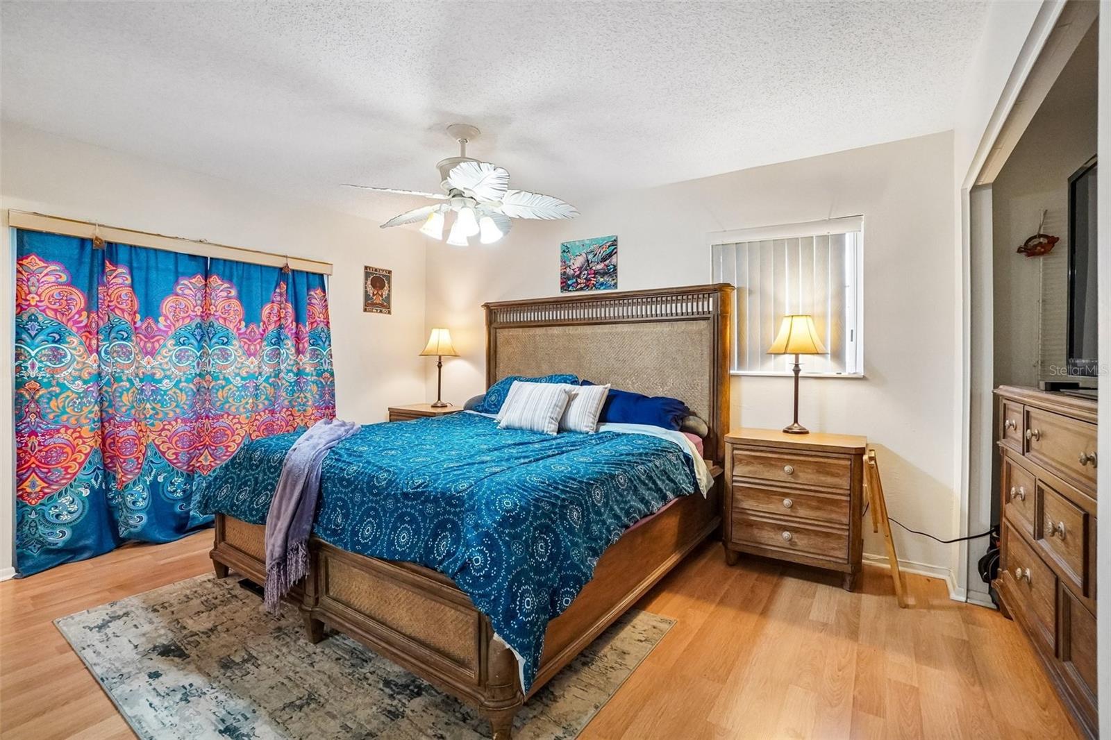 Primary bedroom w/ slider door behind curtains