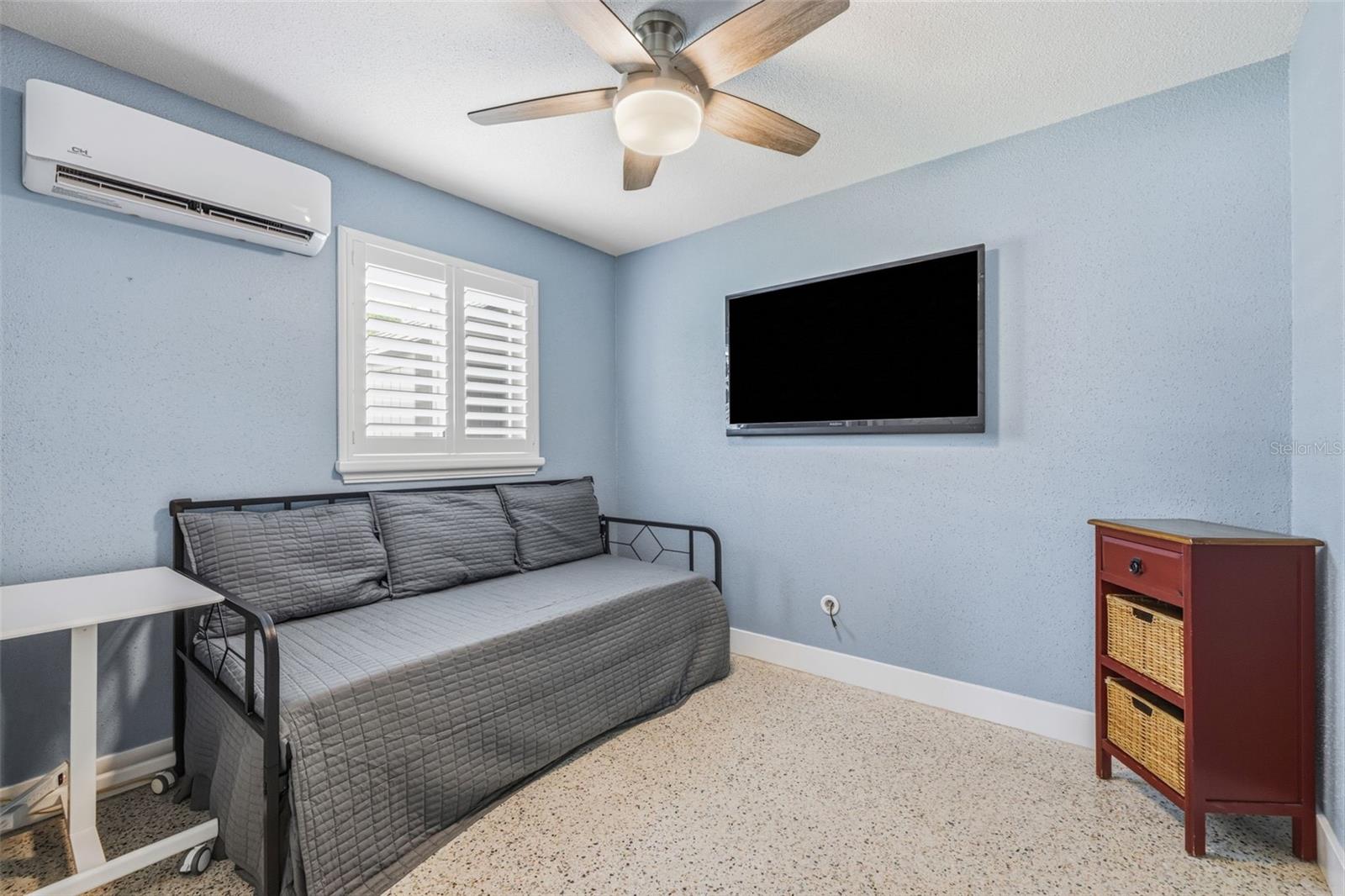 Secondary bedroom features polished Terrazzo flooring, plantation shutters, ceiling fan, mini-split HVAC system with remote.