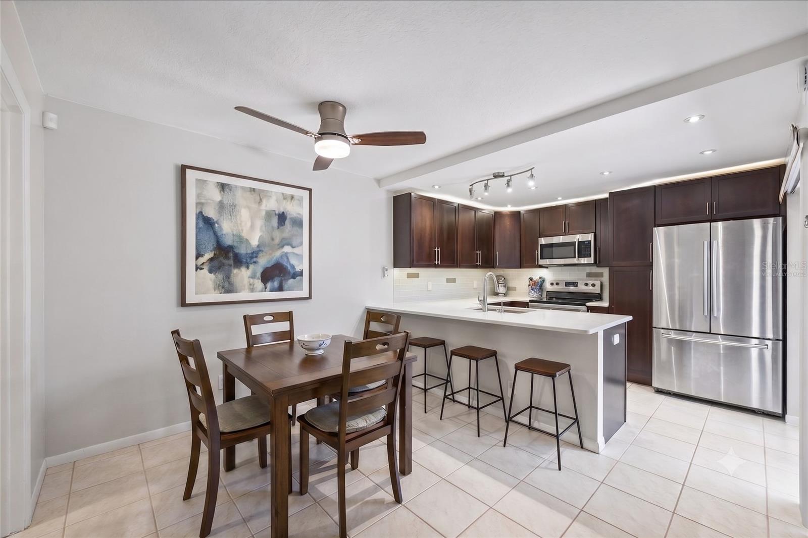 Modern and sleek define this remarkable kitchen and dining space. Sliders lead to the private courtyard, perfect for entertaining. The virtually staged image depicts the ample space offered in the dining area.