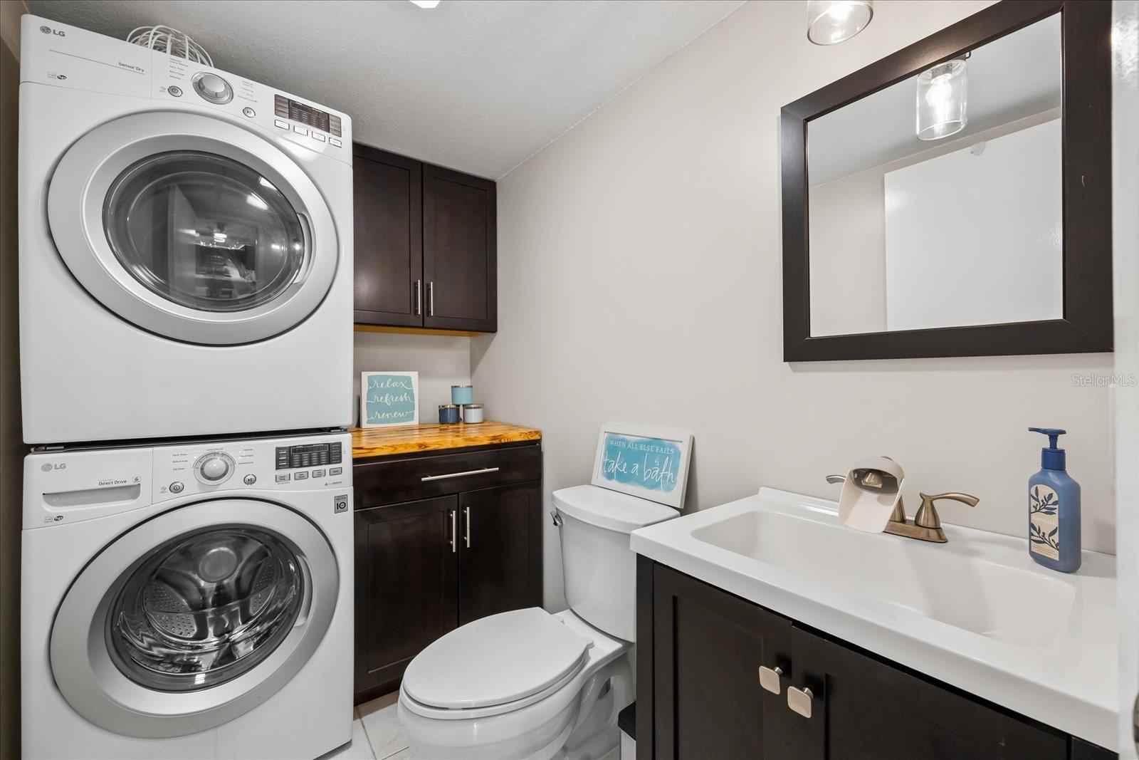 Conveniently located adjacent to the dining, kitchen, and living areas, the half bath serves guests but also functions as the laundry area, optimizing every available space.