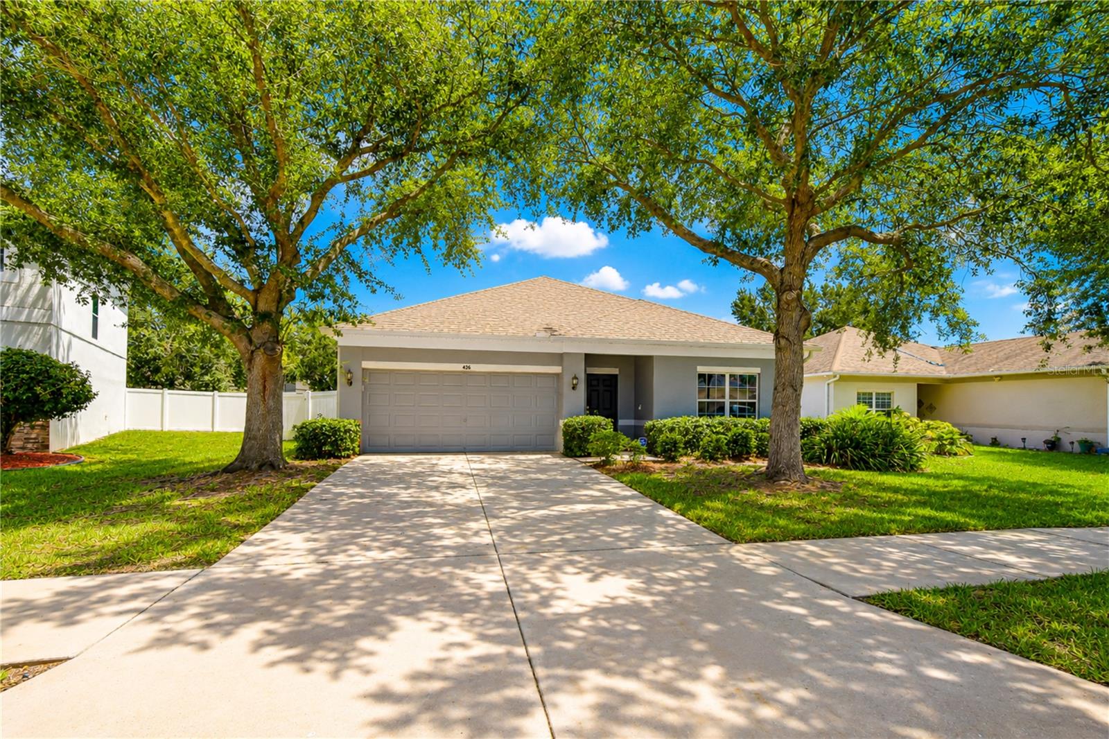 Charming curb appeal with mature oak trees and welcoming architecture.