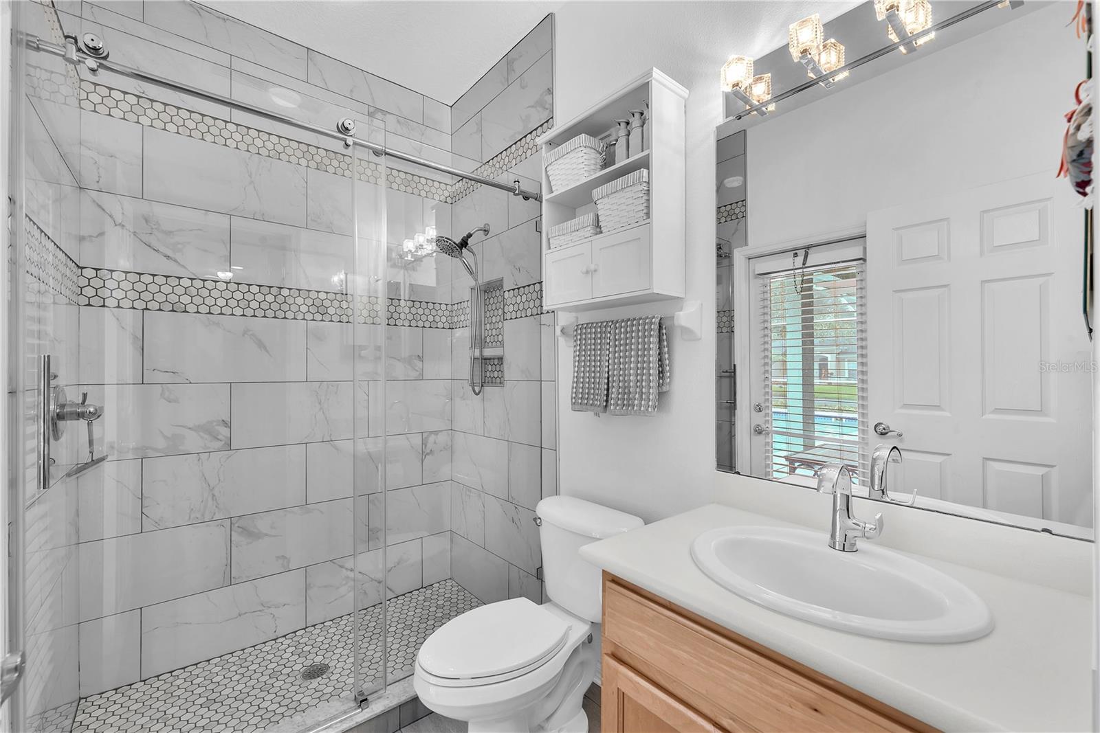 Bathroom #3 with a spacious walk-in shower and exterior access to the pool making entertaining easy while helping keep the main living areas clean and dry.