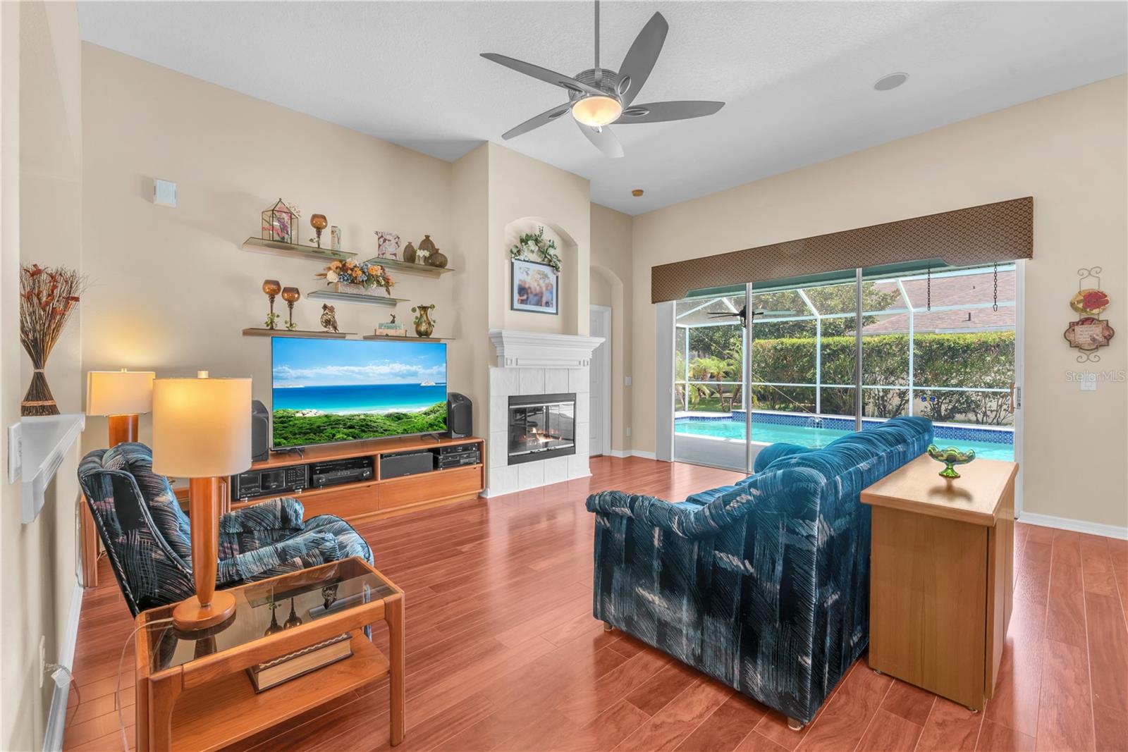 The expansive family room showcases beautiful flooring, wood burning fireplace and triple sliding glass doors that fully open to your own private backyard retreat.