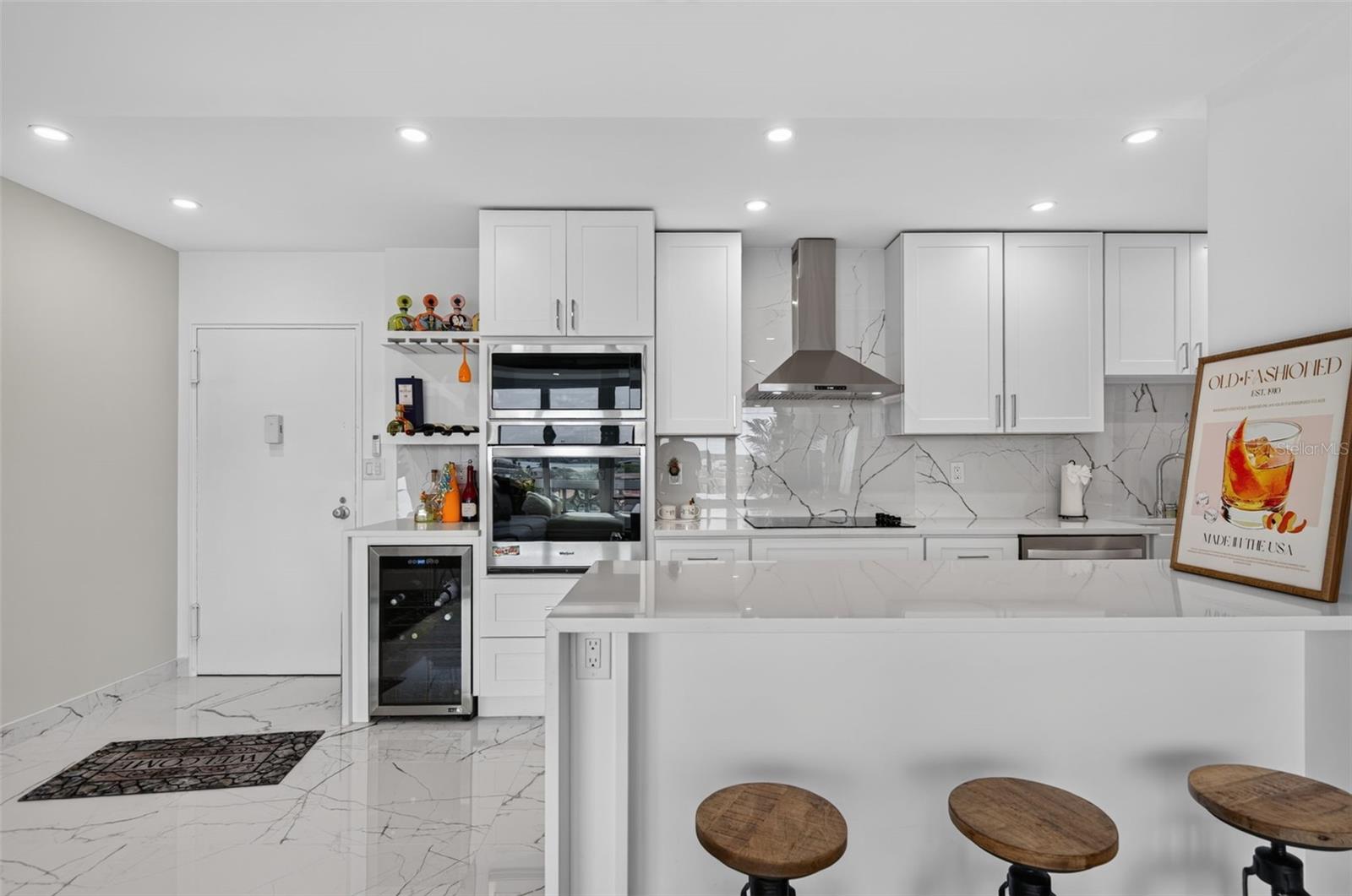 Another view of the kitchen showing built in over and microwave and wine fridge