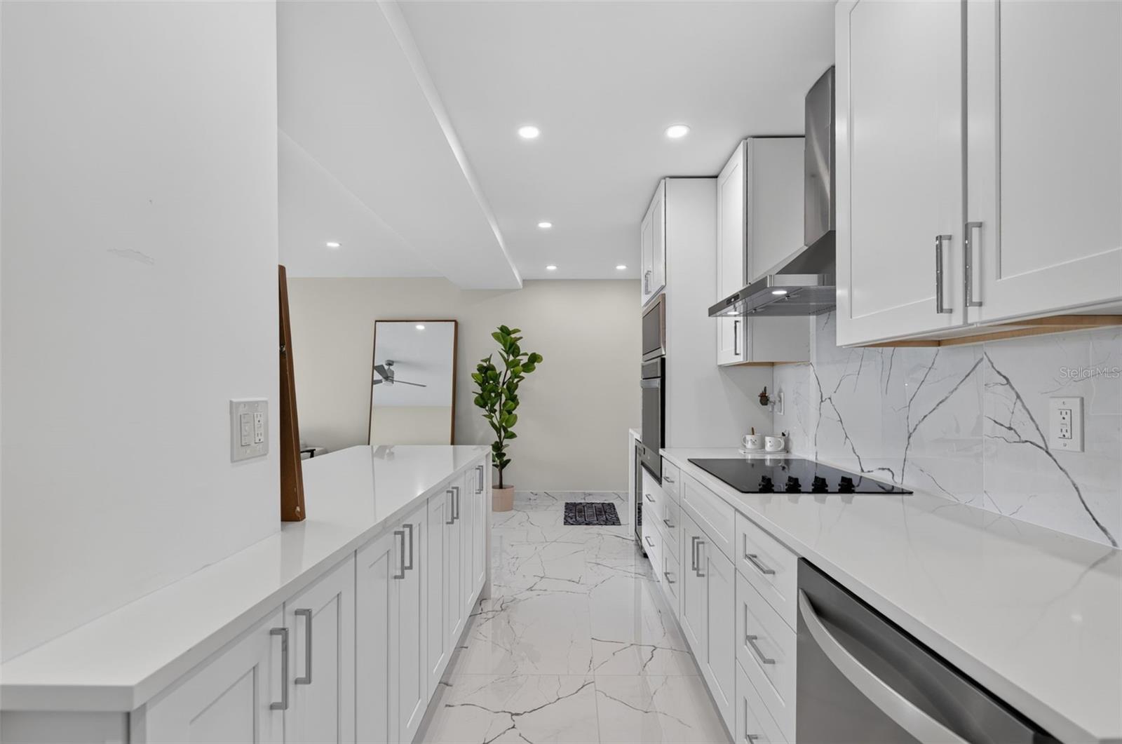 As you enter your home you will see the modern updated kitchen with stainless steel appliances and solid surfact counters and backsplash