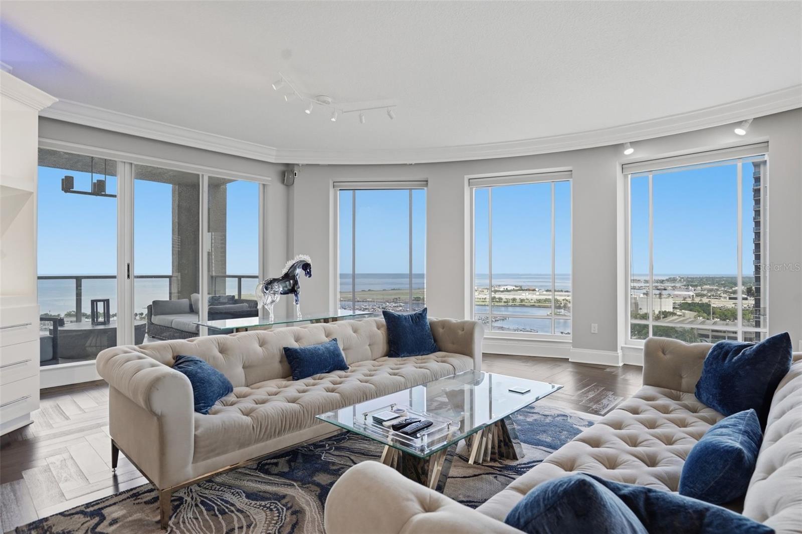 Floor-to-ceiling curved glass with panoramic bay views