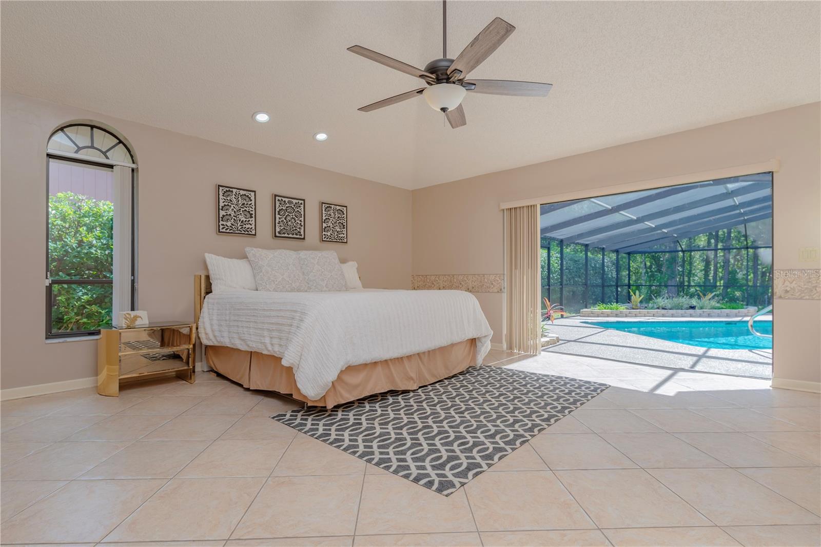 Primary bedroom with triple slider to pool lanai.