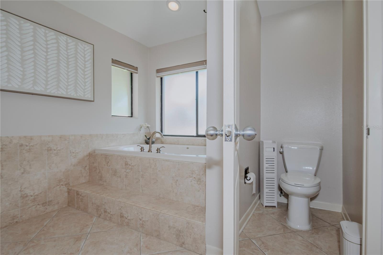 Primary en-suite bathroom with water closet and soaking tub.
