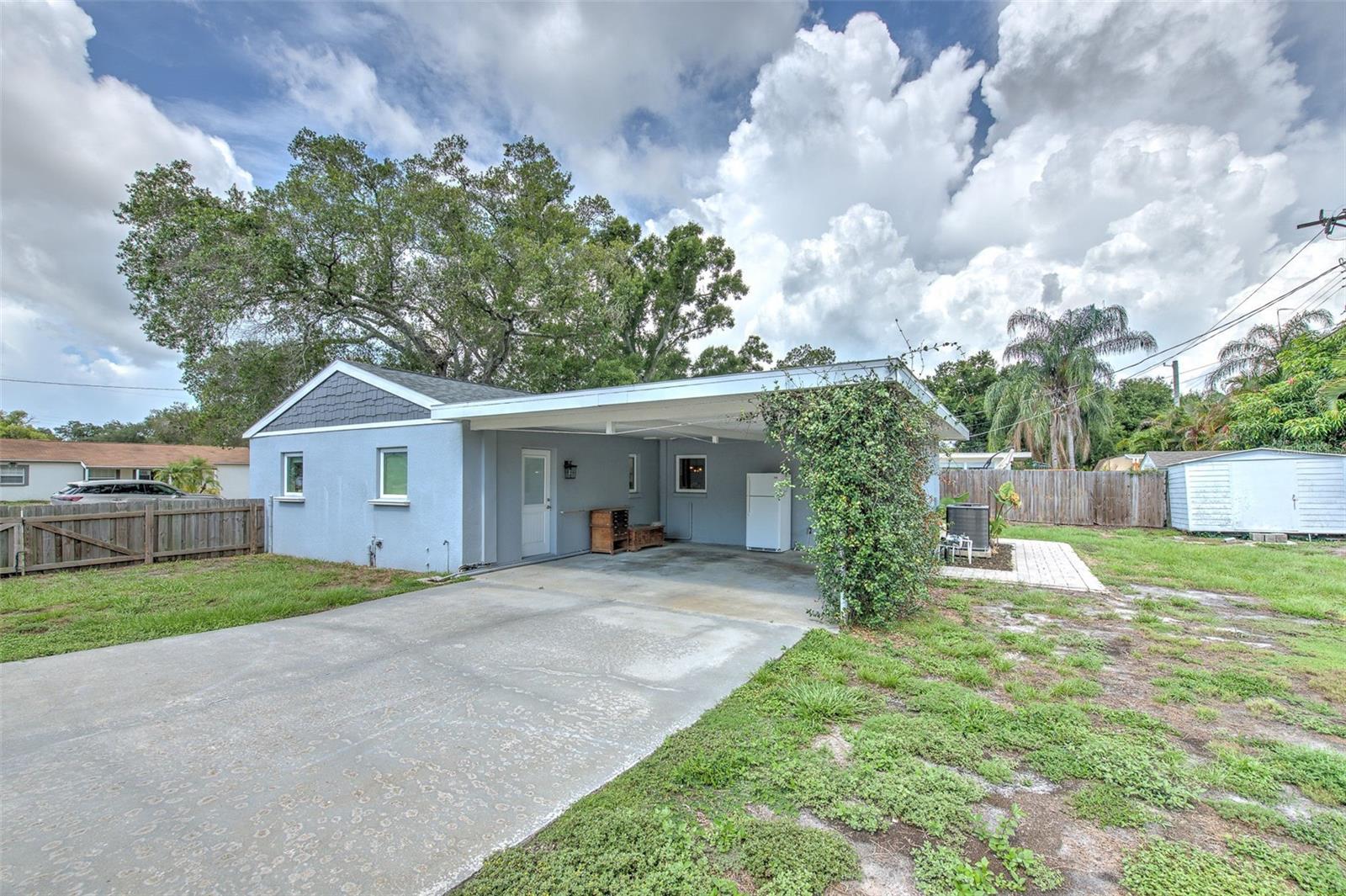 2 space carport with storage shed in backyard