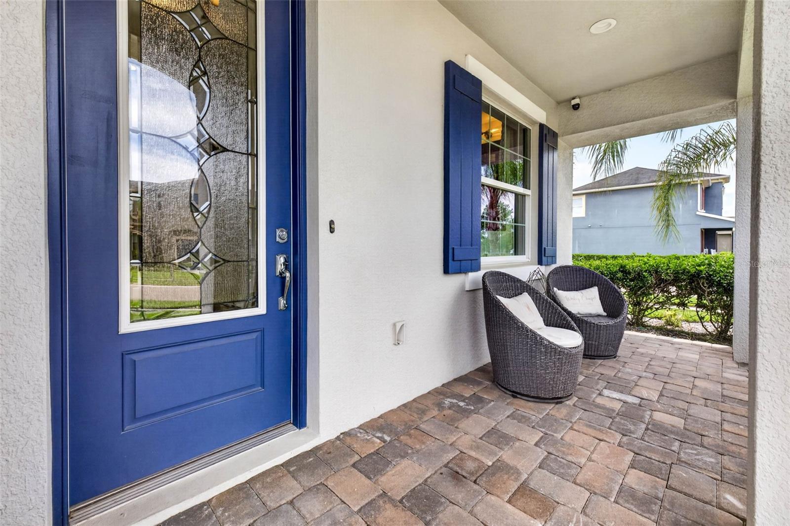 Front patio with glass insert door & seating area.