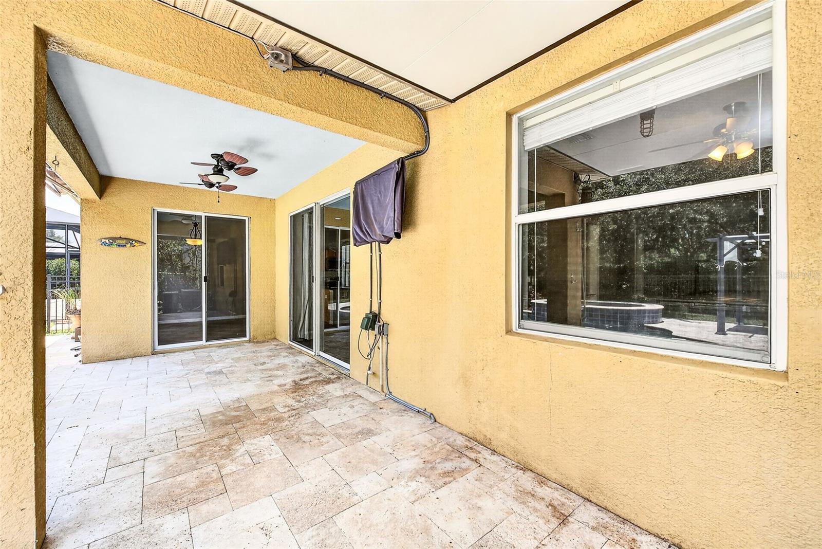 Large covered back porch with travertine pavers