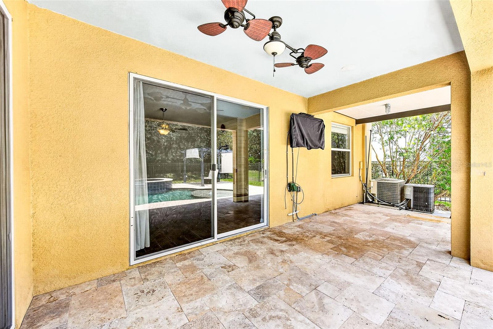 Large covered back porch with travertine pavers