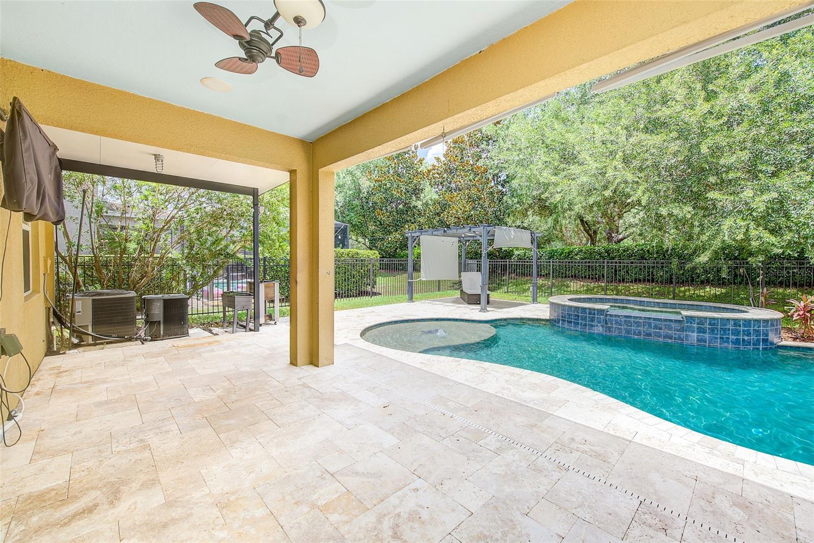 Large covered back porch with travertine pavers