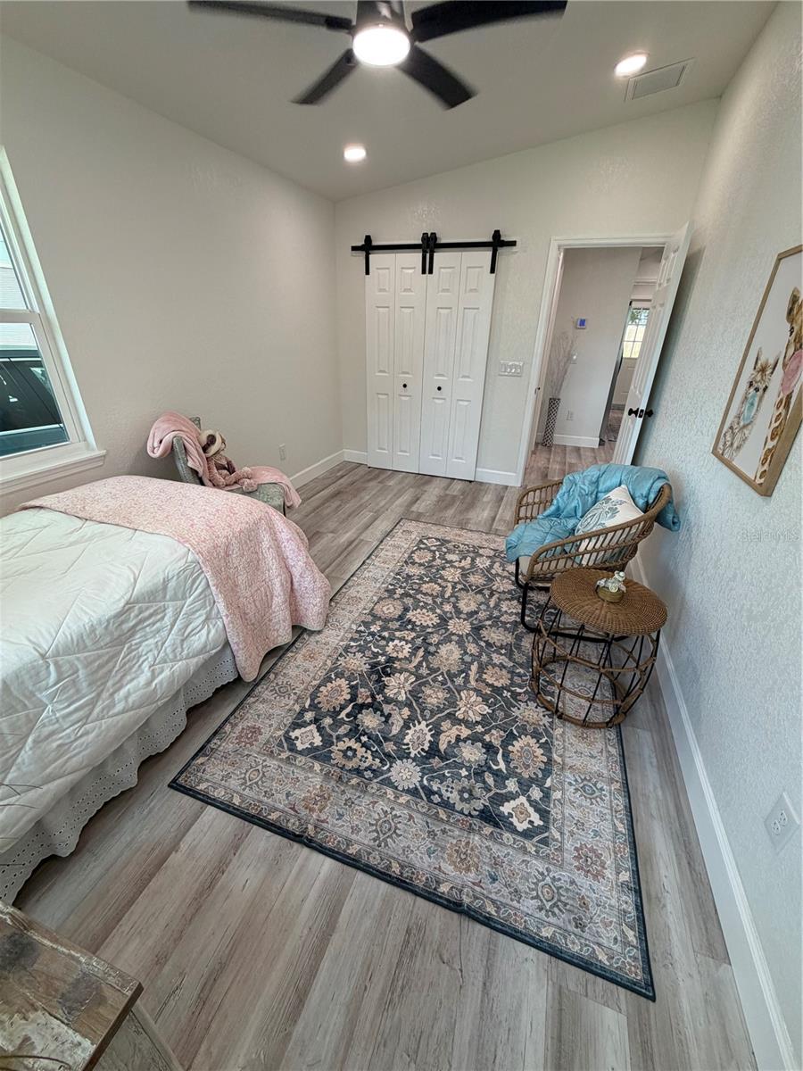 Guest bedroom with fold out barn doors to the closet