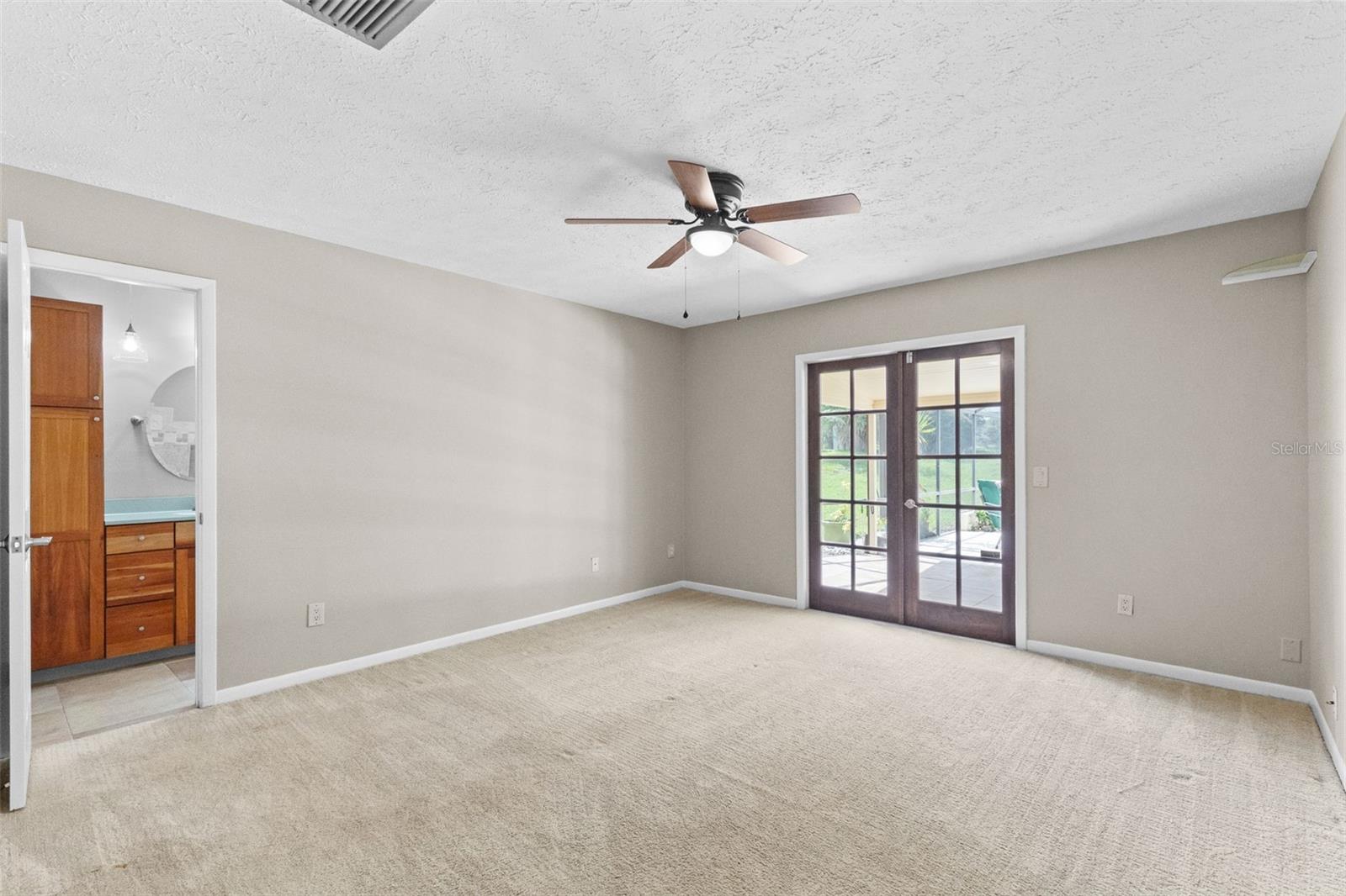 French doors to the lanai and pool from the premium bedroom.
