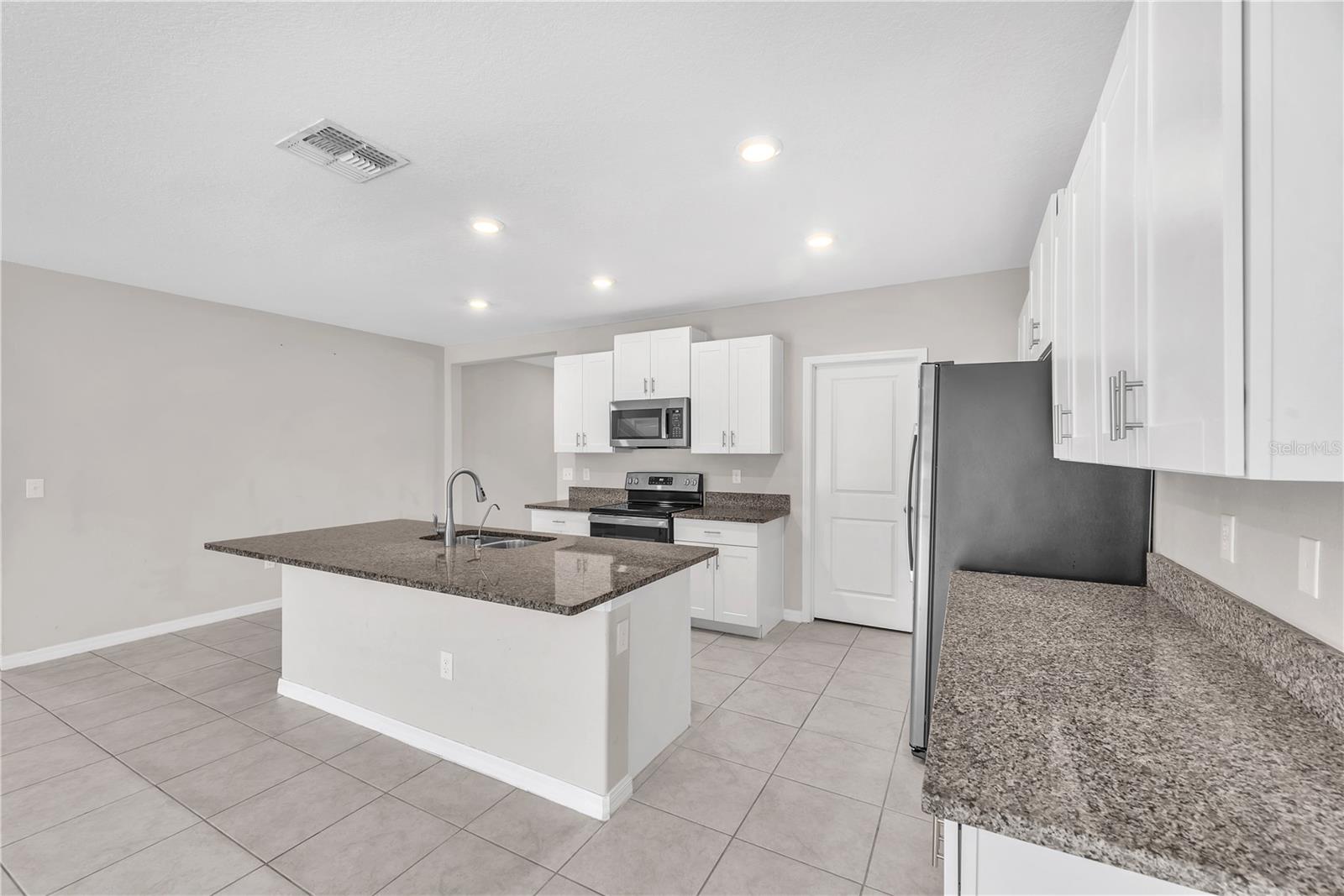 The kitchen island is a work space and provides additional seating.