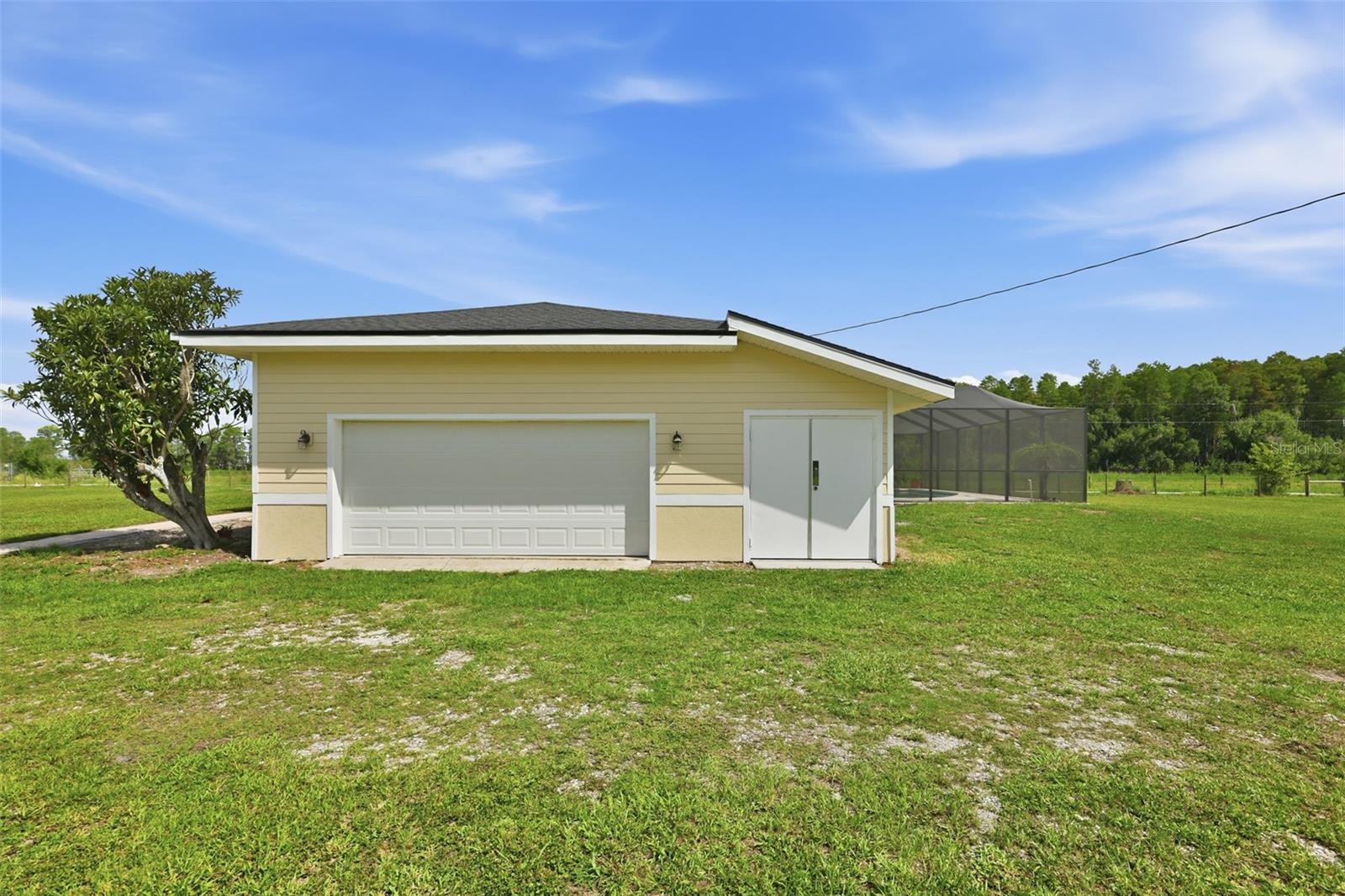 Storage area next to garage with a portable AC unit that conveys with sale