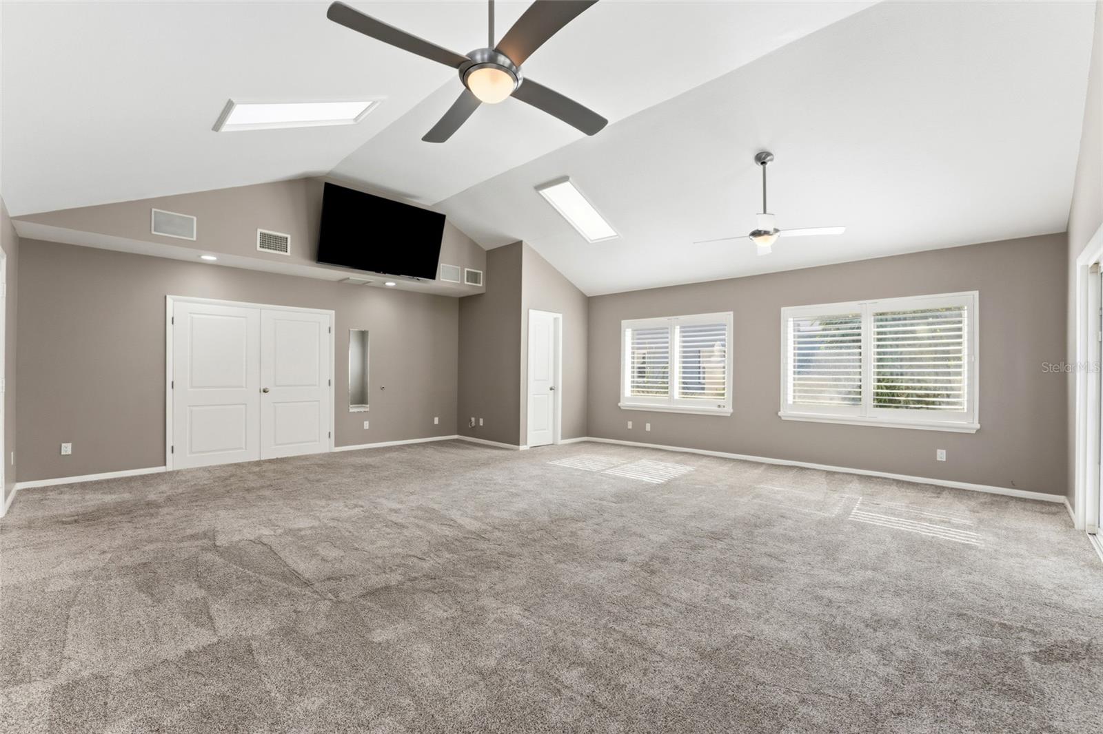 large bonus room with french doors into primary bedroom
