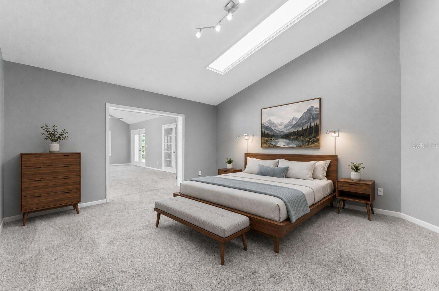 large primary bedroom looking towards bonus room with skylight and shade
