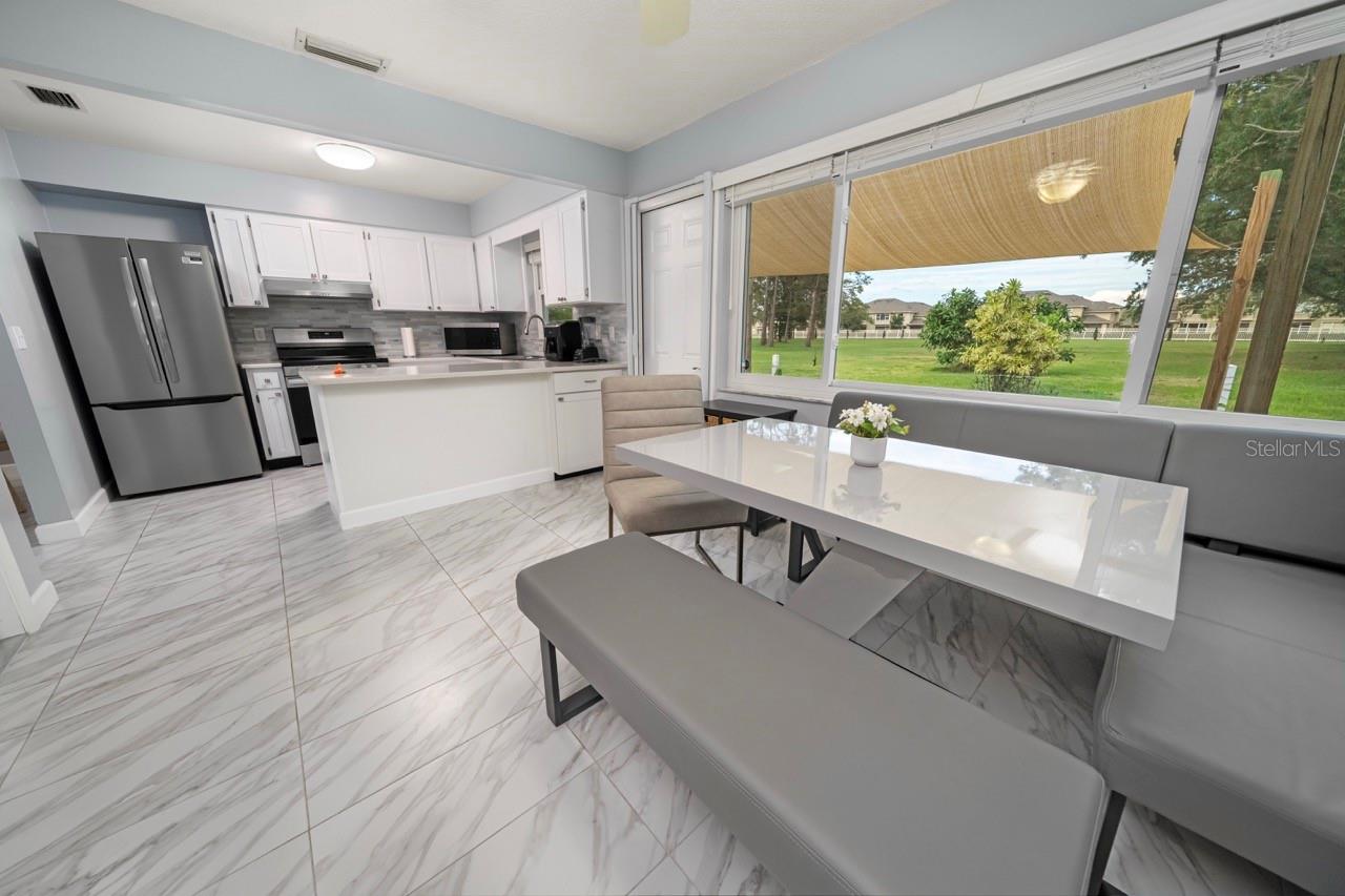 LARGE BREAKFAST KITCHEN NOOK, WITH KITCHEN & CLEAR VIEW OF POND & FOUNTAIN