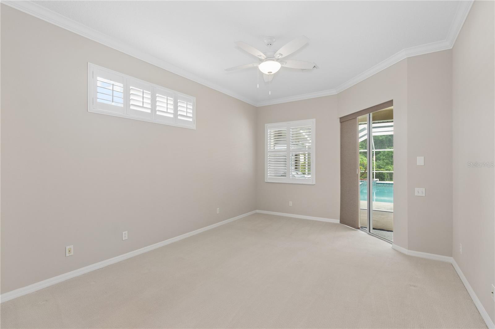 Designed for rest and relaxation, the primary suite features sliding glass doors leading directly to the screened lanai and pool, blending indoor comfort with outdoor serenity.