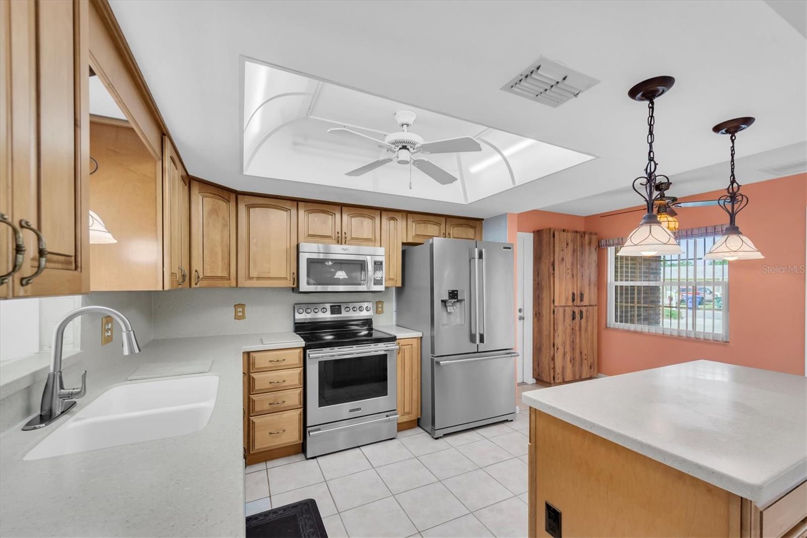 Kitchen with Corian countertops, wood cabinets, and Stainless Appliances
