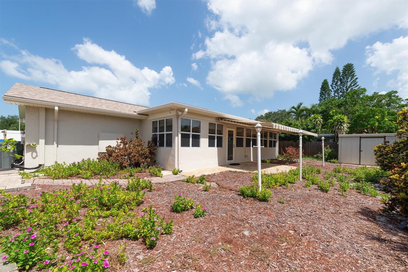 Back Patio with remote controlled Sun Shade Awnings and paver walkways