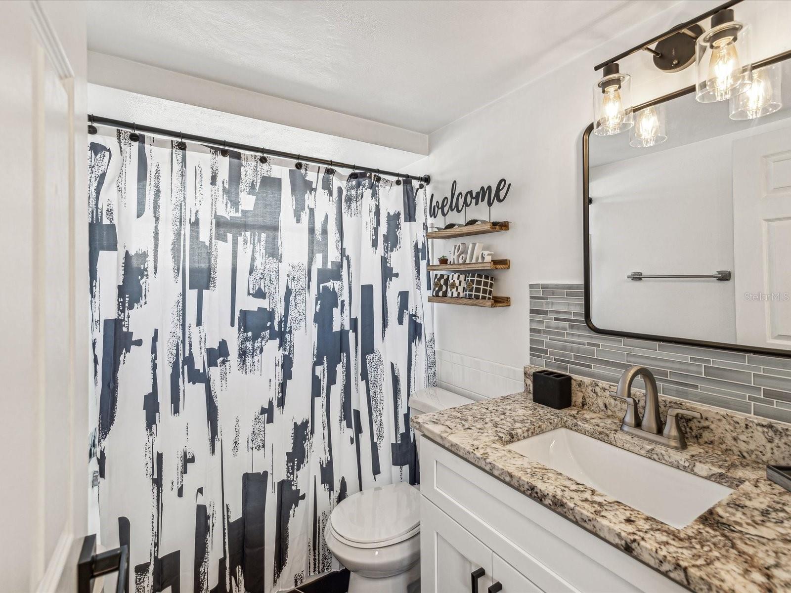 Bathroom #1 with granite vanity and tub/shower combo.
