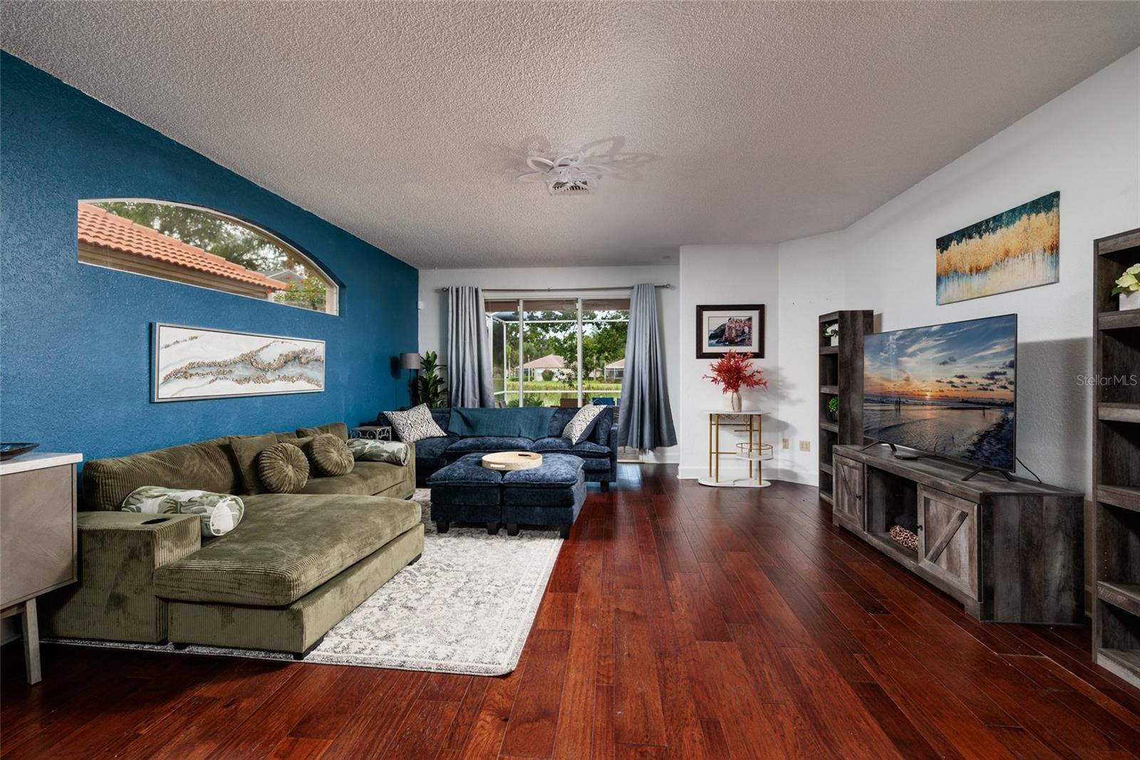 Living room with sliders to a large lanai with pond view.