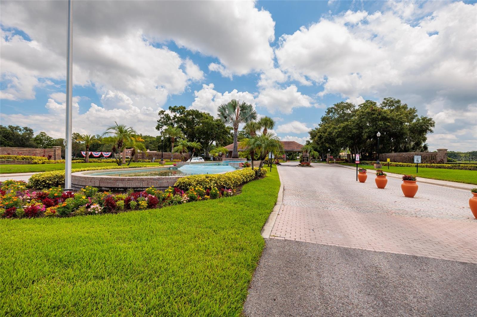 Entering Crescent Oaks, greeting by beautiful landscaping and the guarded entry
