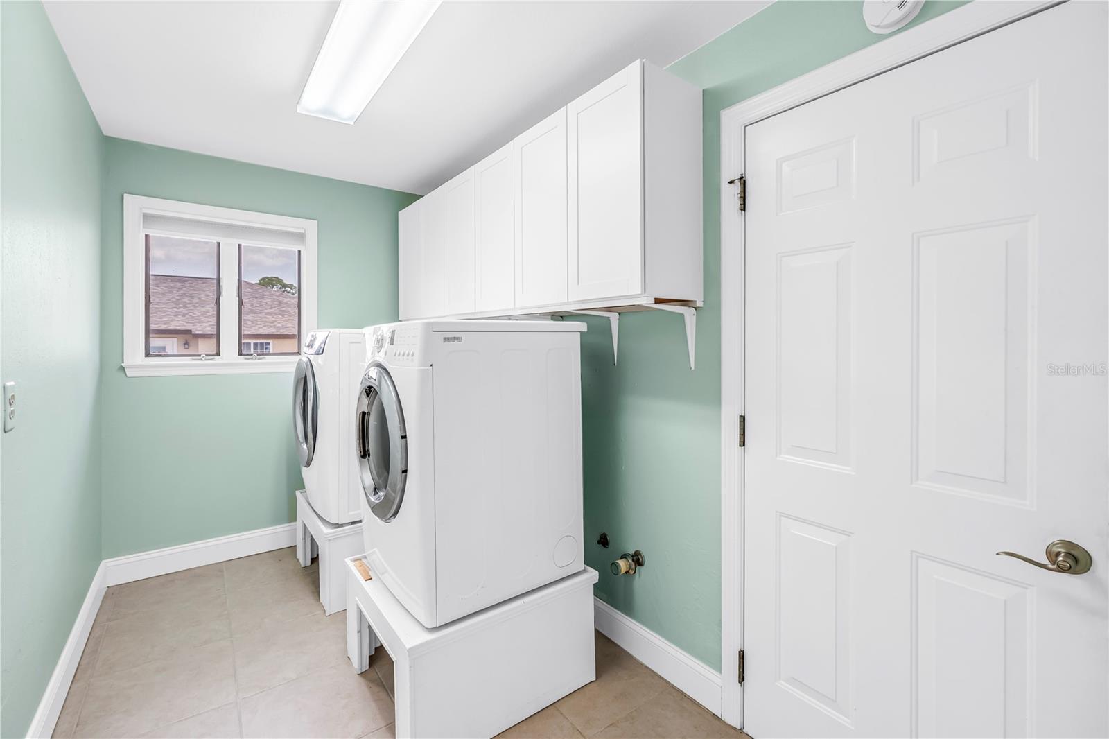 Large indoor laundry with storage - door leads to garage