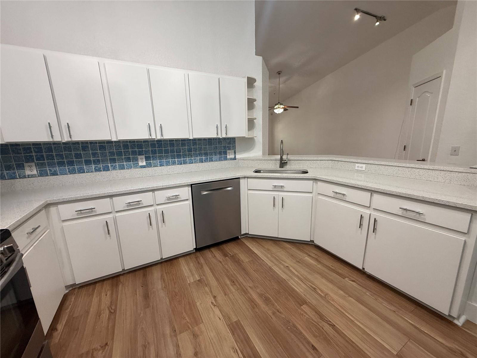 Luxury vinyl plank flooring throughout the home. Kitchen opens to living/dining.