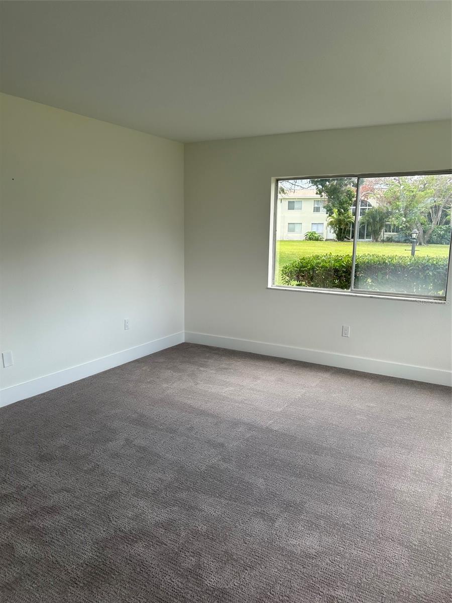 Primary bedroom with view of the grounds in rear of the building.
