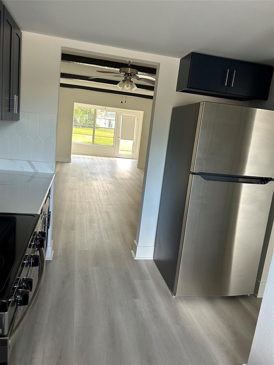 Looking from kitchen through dining and living areas to the Florida room and back door beyond.