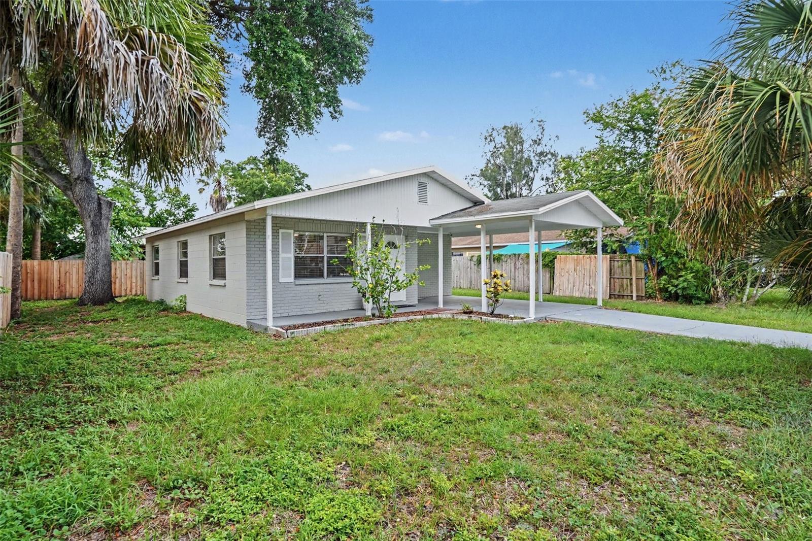 Fresh curb appeal with concrete block construction and a covered carport.