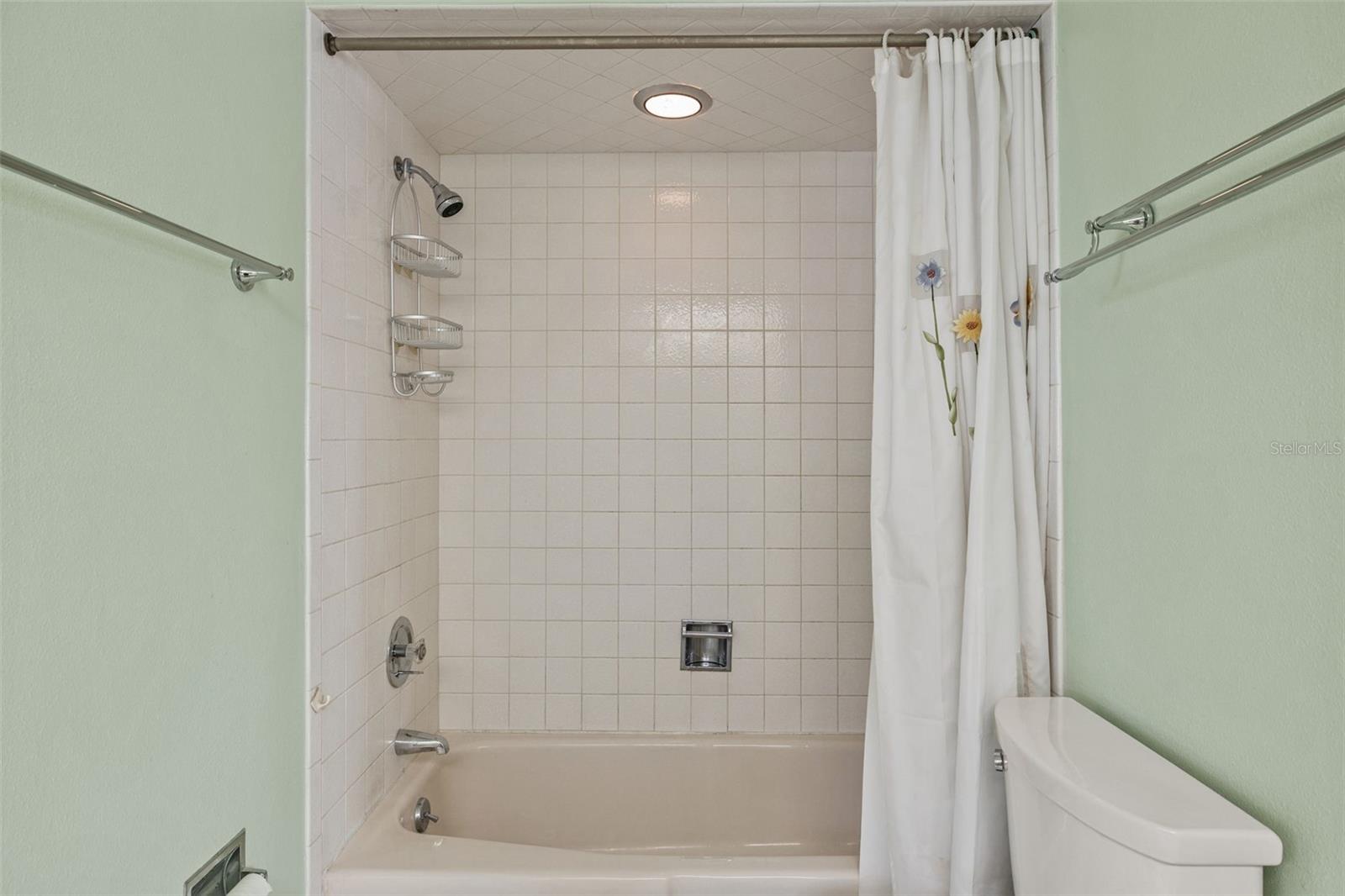 A tiled tub-and-shower combo completes this full Jack and Jill bathroom, offering a simple, easy-to-maintain space for daily routines.