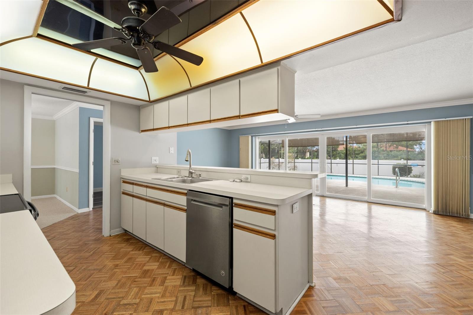 Another angle of the kitchen highlights the efficient galley layout and the play of natural light from the domed skylight overhead across the wood-trimmed cabinetry.