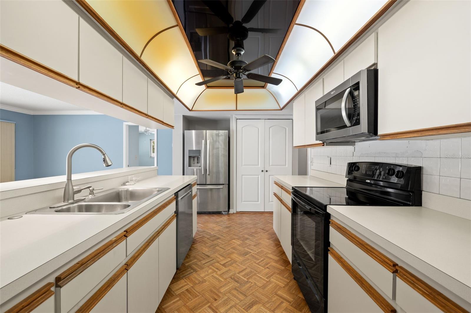 Ample counter space runs along both walls of the kitchen, offering room to prep and plate with ease, while the arched, sunlit ceiling keeps the galley layout from feeling closed in.