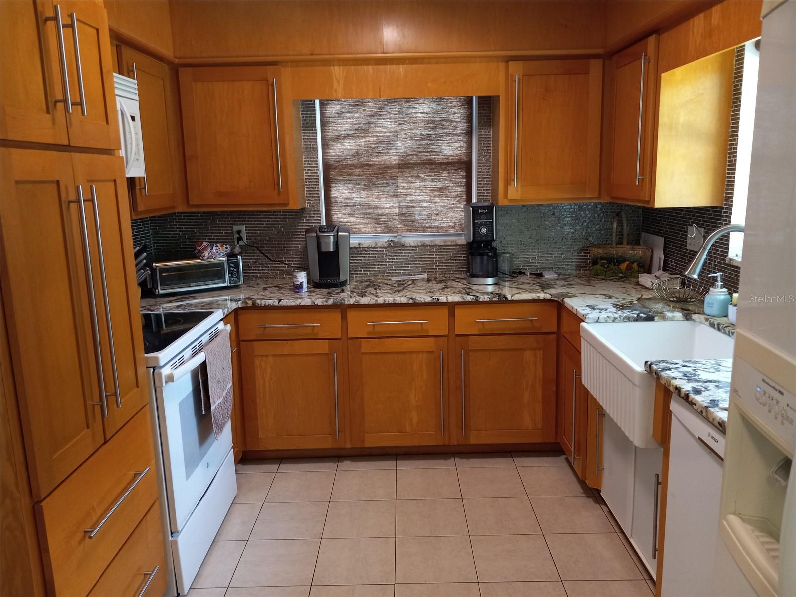 looking into kitchen from eat-in area.  Kitchen has "farm house" sink