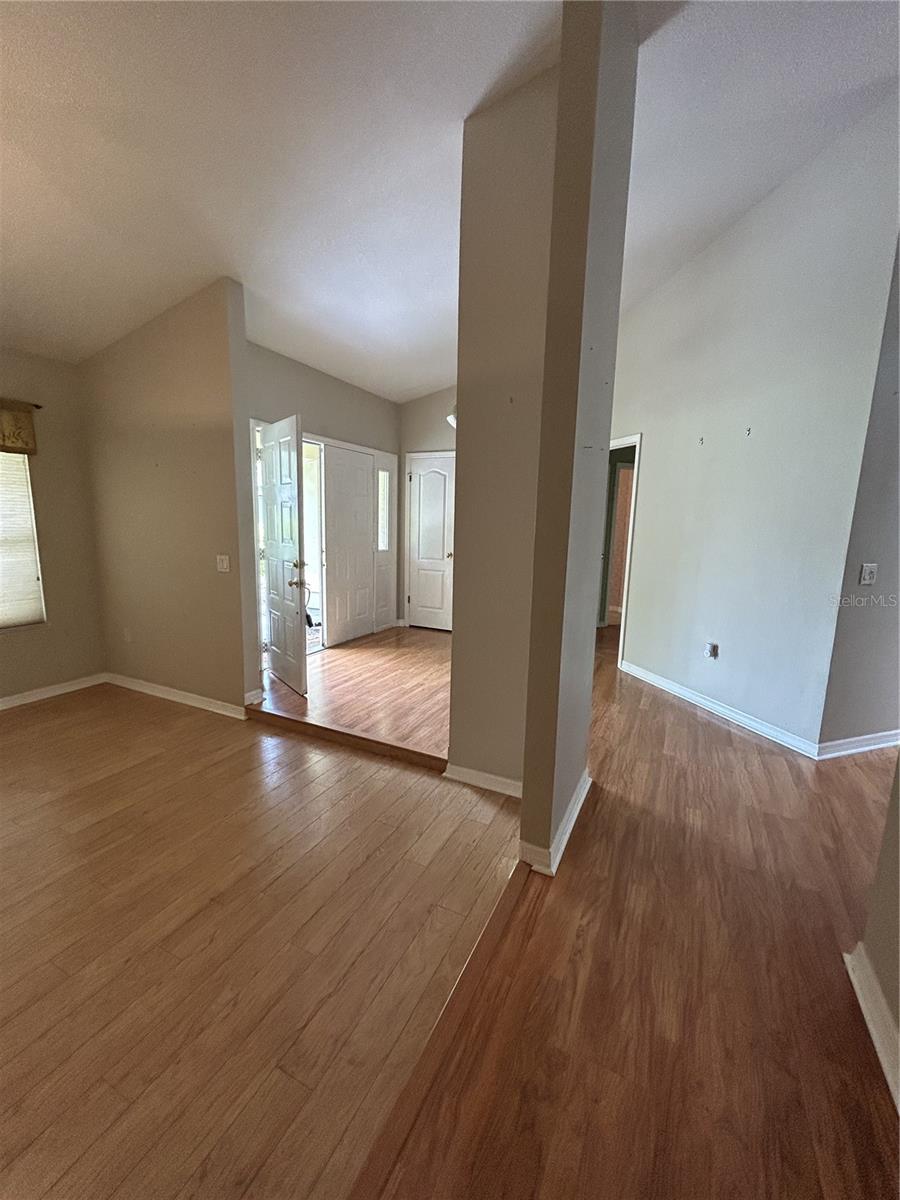 View from door leading to garage showing the formal dining room on the left, kitchen would be on the right, and entry.