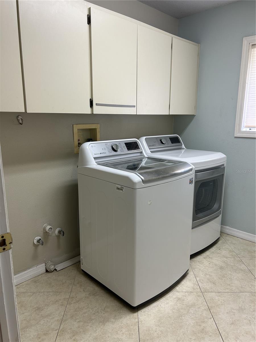 Indoor laundry room with cabinets.