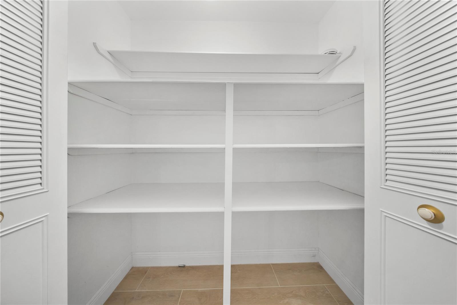 Hallway Behind Kitchen Leads to Closet and Bedrooms