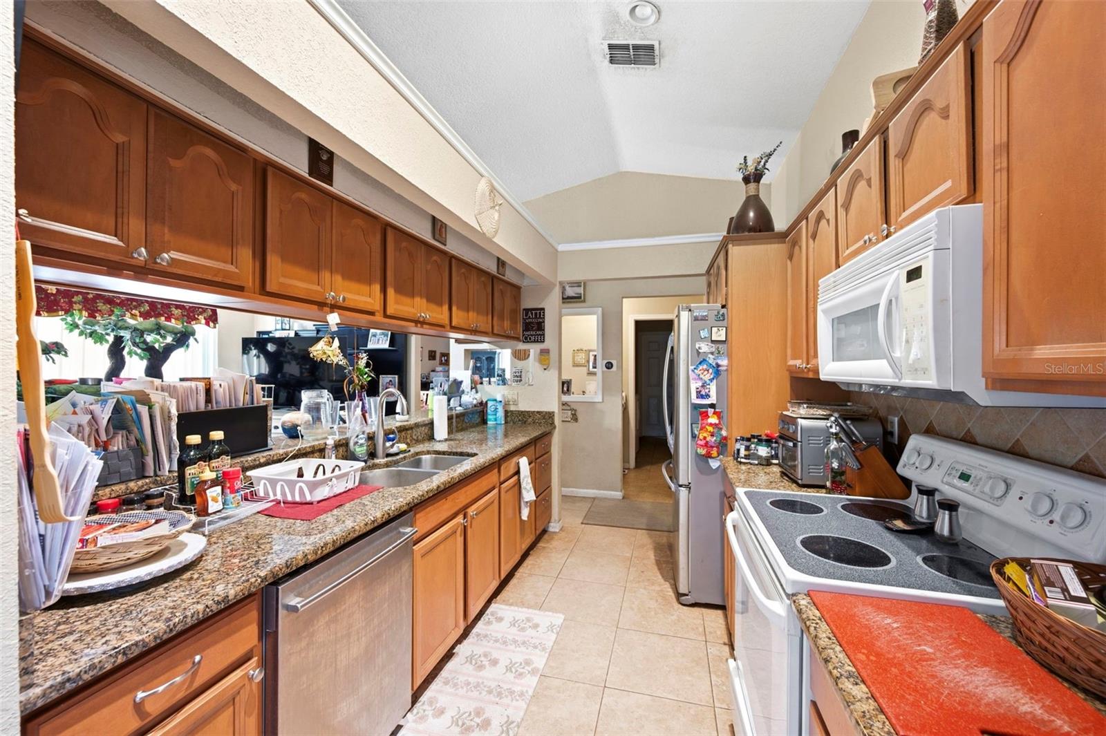 The kitchen features granite counters, abundant cabinets and a breakfast bar open to the family room