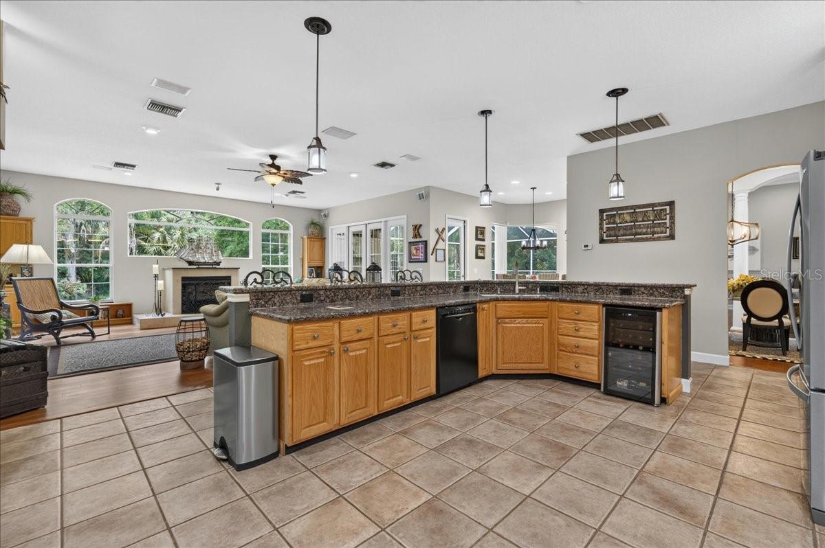 The spacious, well-appointed kitchen features abundant oak cabinetry, granite countertops, stainless steel appliances, a gas range, wine storage and an elevated breakfast bar with seating overlooking and flowing seamlessly into the family room and breakfast nook.