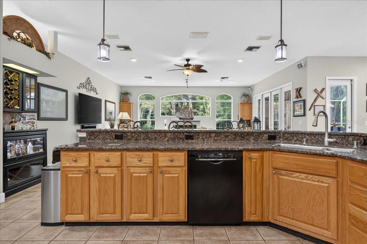 The spacious, well-appointed kitchen features abundant oak cabinetry, granite countertops, stainless steel appliances, a gas range, wine storage and an elevated breakfast bar with seating overlooking and flowing seamlessly into the family room and breakfast nook.