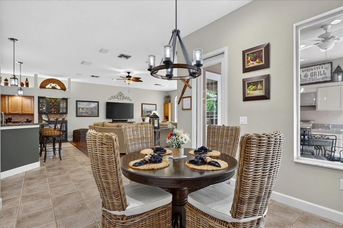 The adjoining breakfast nook is framed by a mitered-glass corner window overlooking the pool and preserve.