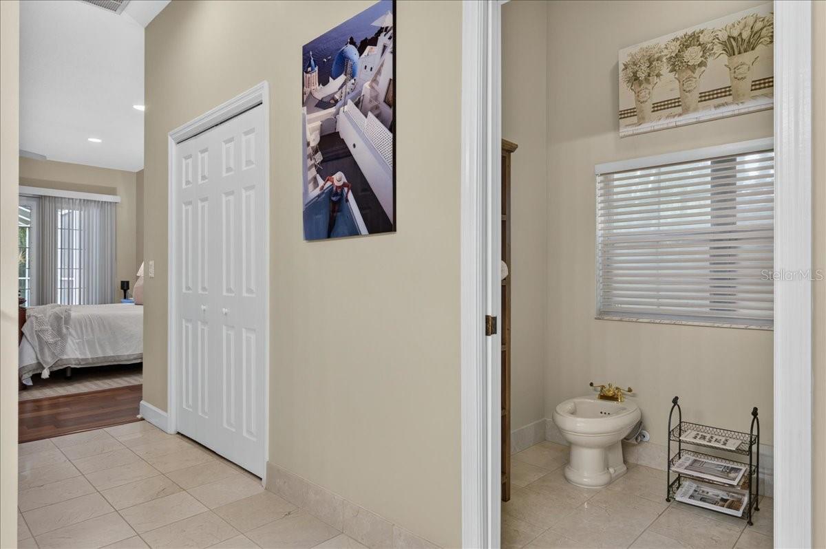 The ensuite bath offers extensive marble finishes, soaking tub, an oversized shower with a curved glass-block wall, double-sink vanity, and a separate water closet with bidet.